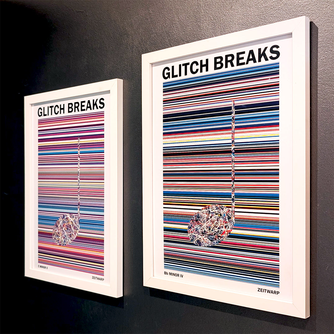 A pair of multicoloured Music Art prints in white frames on a grey painted gallery wall