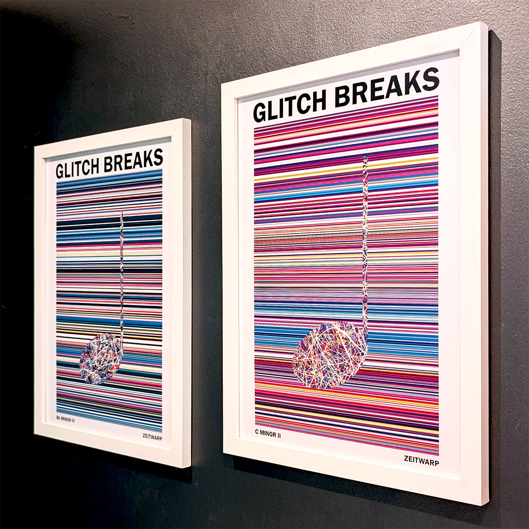 A pair of multicoloured Music Art prints in white frames on a metallic grey painted gallery wall