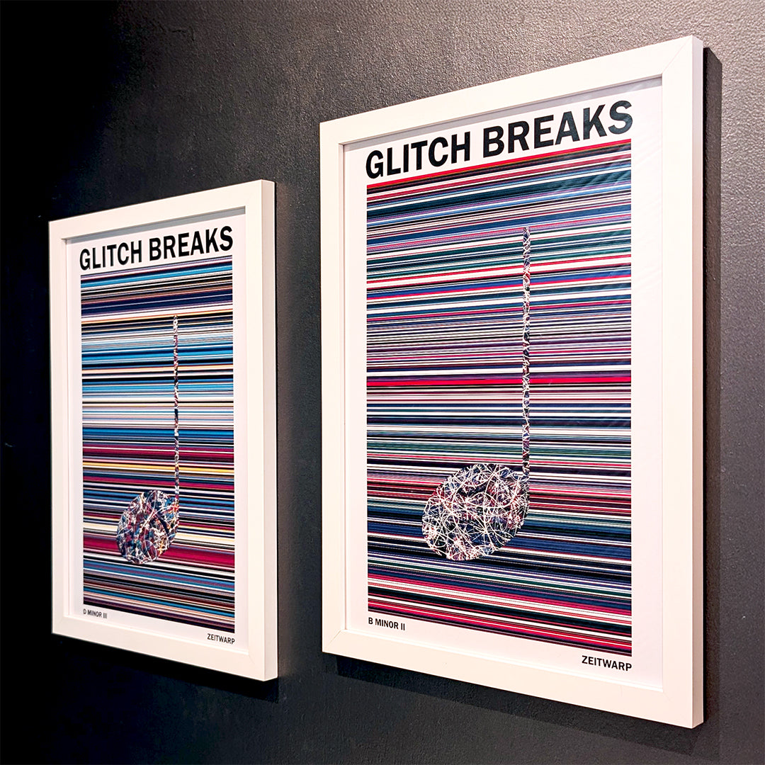 A pair of multicoloured Music Art prints in white frames on a metallic grey painted wall
