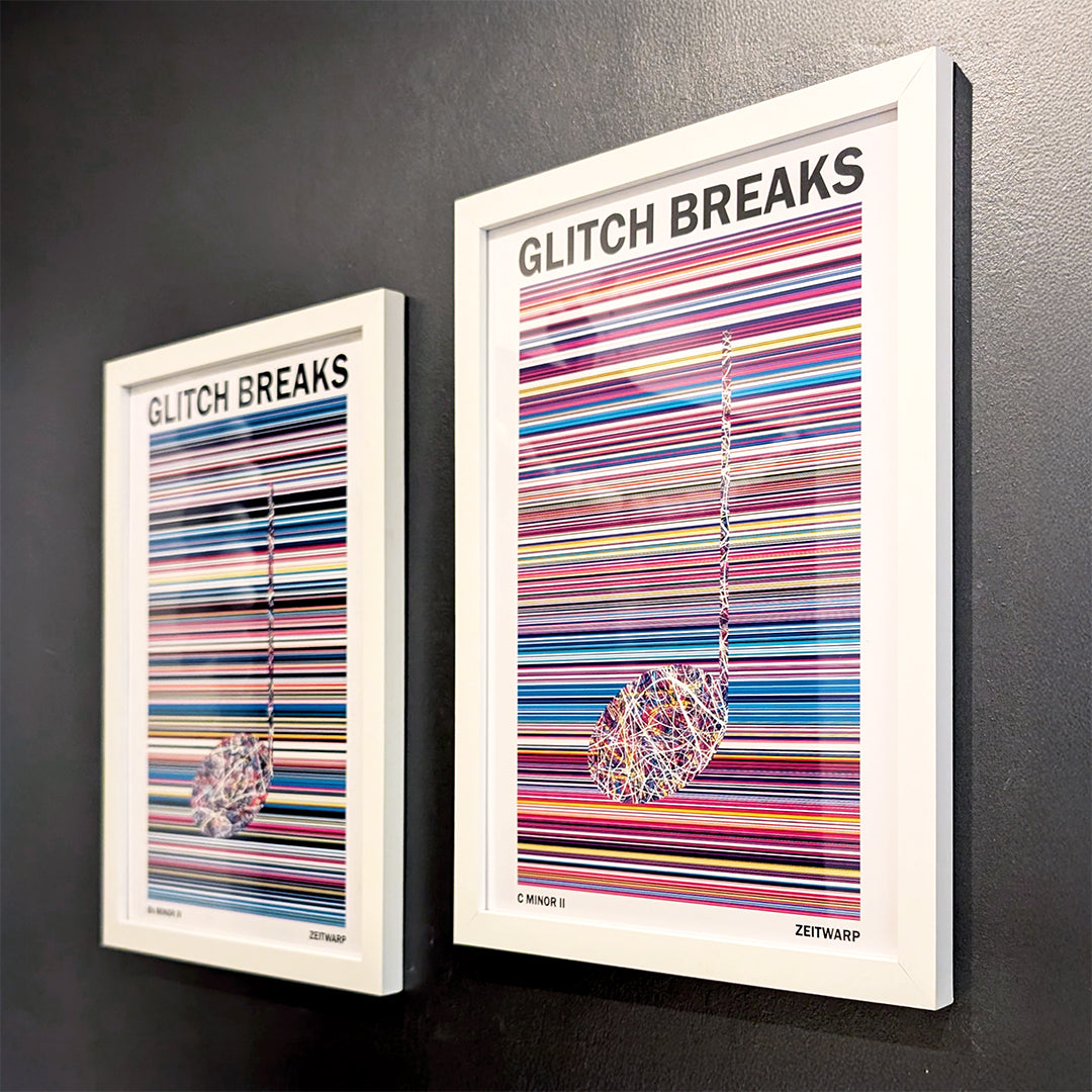 A pair of multicoloured Music Art prints in white frames on a metallic grey painted gallery wall