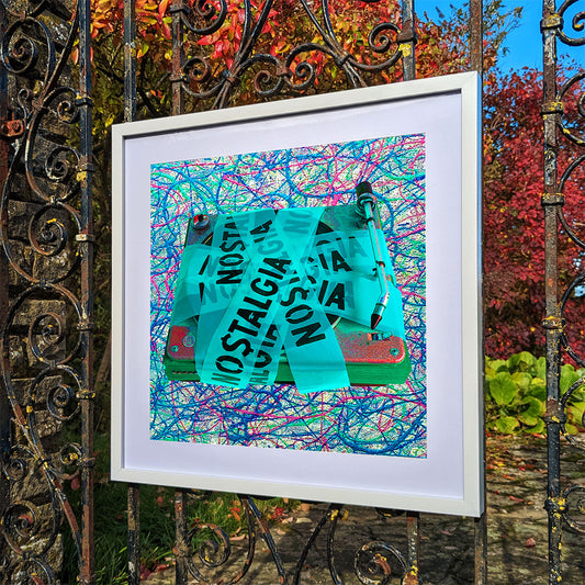 Framed art print of a turquoise turntable hanging on an old iron gate