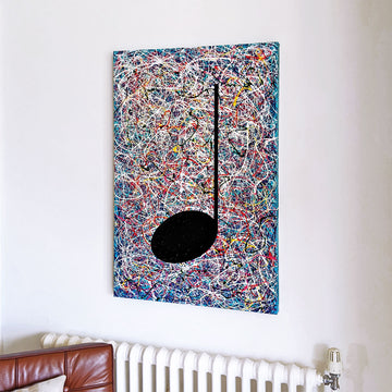 Blue, white and multicoloured abstract music painting hanging on a white wall above a radiator and a brown chair