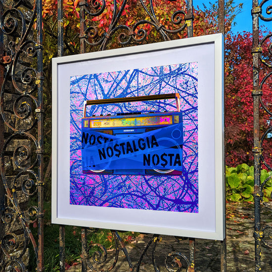 Framed art print of a purple boombox hanging on an old iron gate