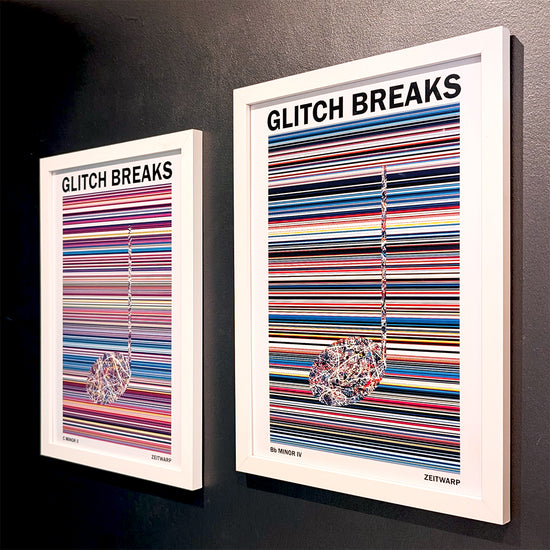 A pair of multicoloured Music Art prints in white frames on a grey painted gallery wall