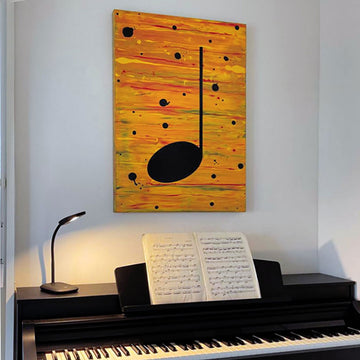 Yellow and black music themed  painting hanging on a white wall above a black piano