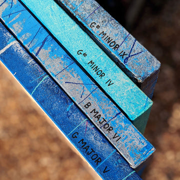 Four mostly blue Music Graffiti paintings viewed from the side to display their names