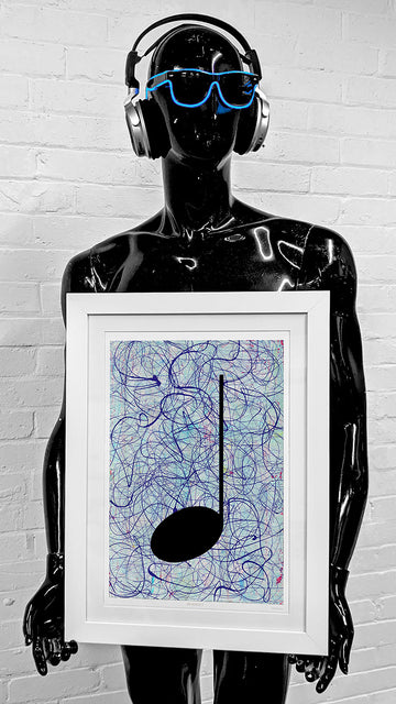 Black Robot Mannequin with blue sunglasses holding a framed silver and black Music Art print, standing in front of a white brick wall