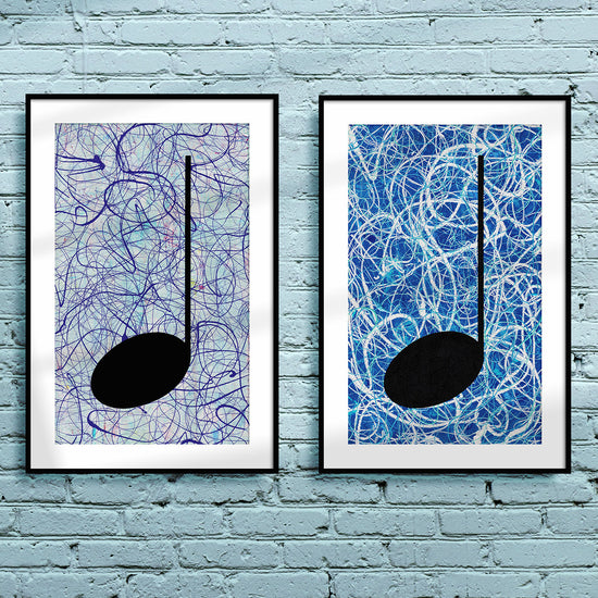 Pair of framed silver and blue Music themed Giclée Prints on a light blue brick wall