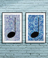 Pair of framed silver and blue Music themed Giclée Prints on a light blue brick wall