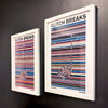 A pair of multicoloured Music Art prints in white frames on a grey painted gallery wall