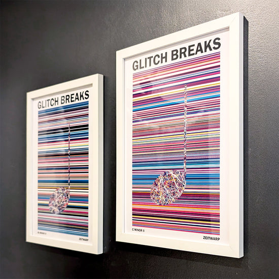 A pair of multicoloured Music Art prints in white frames on a metallic grey painted gallery wall