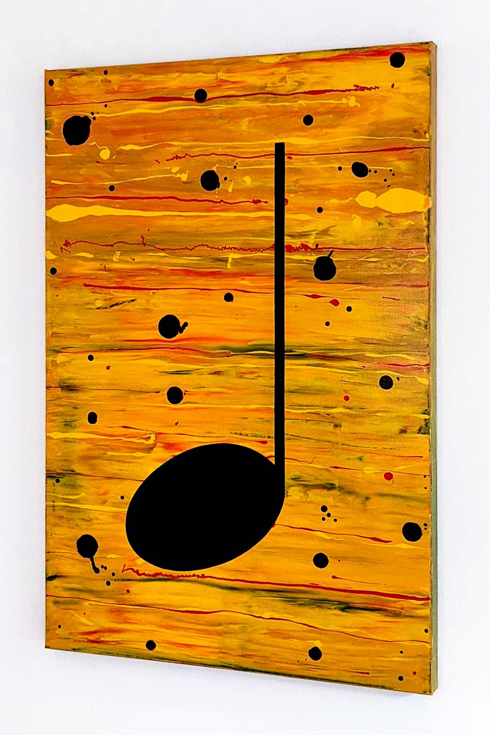 Yellow and black music themed painting hanging on a white wall, viewed at an angle